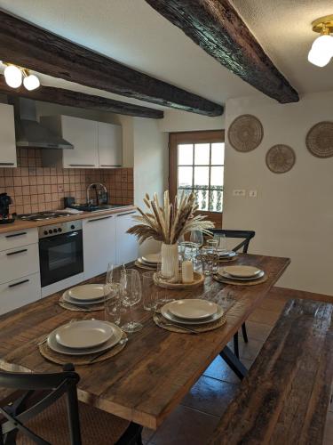 - une cuisine avec une table en bois, des assiettes et des verres à vin dans l'établissement La Maison des Potiers avec Terrasse et Parking, à Kaysersberg