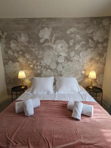 une chambre avec un grand lit avec deux serviettes dessus dans l'établissement La Maison des Potiers avec Terrasse et Parking, à Kaysersberg