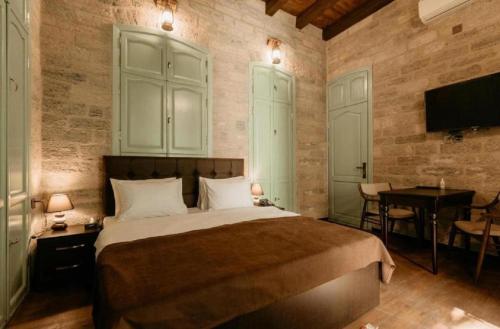 a bedroom with a bed and a desk and a television at Royal Qala Hotel in Baku