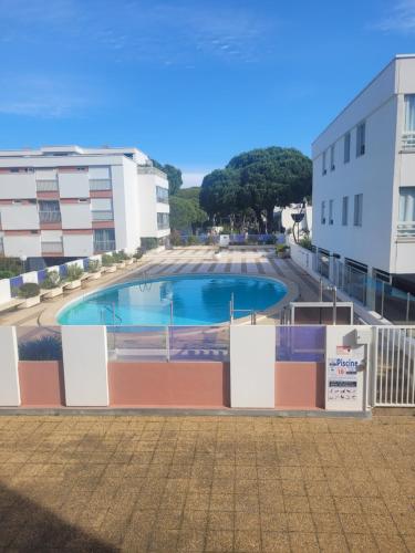 une piscine au milieu d'un immeuble dans l'établissement Charmant Appartement Rénové pour 5 Personnes – Résidence avec Piscine et Parking – La Grande Motte, à La Grande Motte