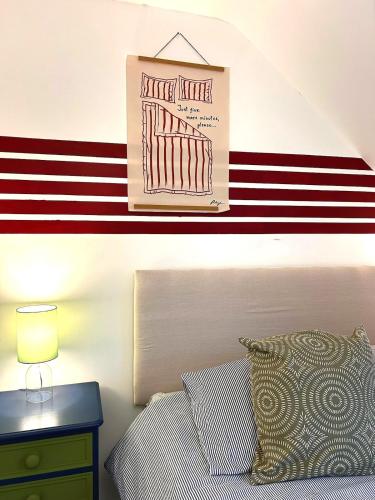 a bedroom with a red and white striped wall at 8 - Mouse Hole, Norfolk in Sparham