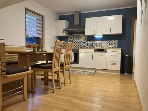 a kitchen with white cabinets and a table and chairs at Ferienwohnung in Moosburg 