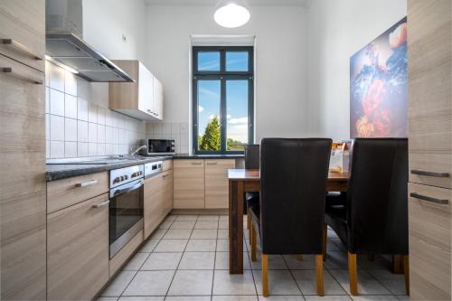 a kitchen with a wooden table and black chairs at InselLiebe mit Seeterrasse in Malchow