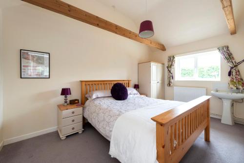 a bedroom with a bed and a sink at Buckingham Cottage - Lancombes House in Powerstock