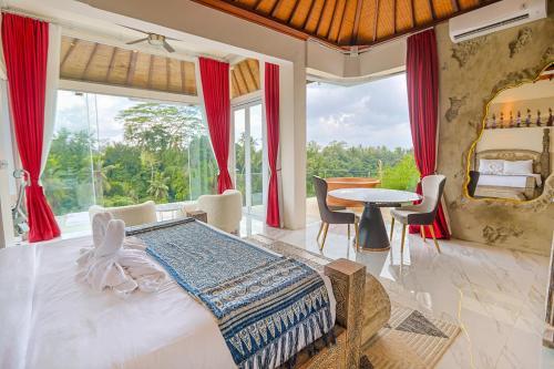 a bedroom with a large bed and a table at Villa Cella Bella Ubud in Ubud