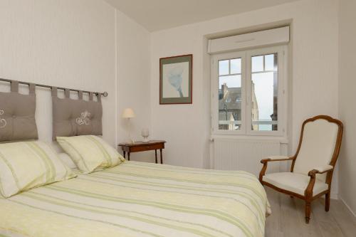 une chambre avec un lit, une chaise et une fenêtre dans l'établissement Maison du Pecheur, à Cancale
