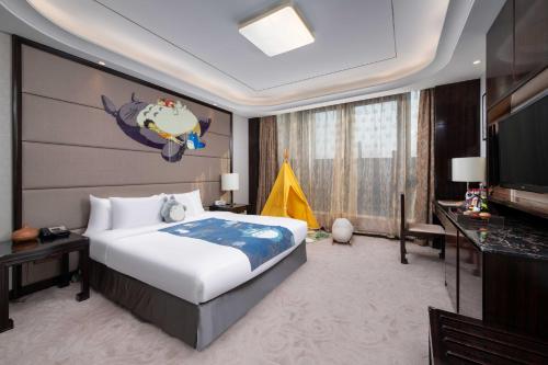 a bedroom with a large bed and a television at Wyndham Grand Plaza Royale Changsheng Jiangyin in Jiangyin