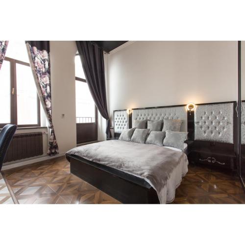 a bedroom with a king sized bed and windows at In the heart of the city in Kharkiv