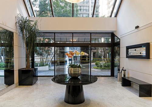a large glass vase sitting in the middle of a lobby at Central Park Flat Jardins in Sao Paulo