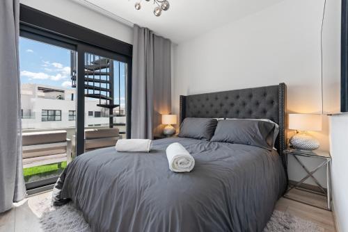 sypialnia z dużym łóżkiem i dużym oknem w obiekcie Casa Diamante - Estepona w mieście Estepona