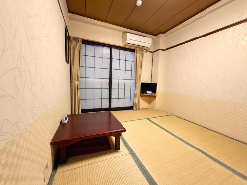 a room with a table and a large window at Business Ryokan Akashiya Annex in Akashi