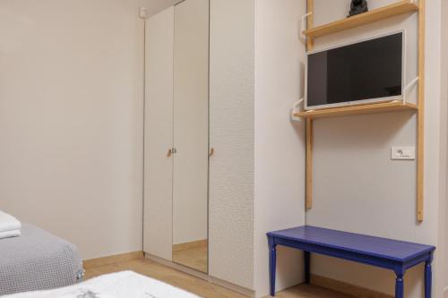 a bedroom with a tv and a blue table at Villa Shangri-La Zakinthos in Zakynthos Town