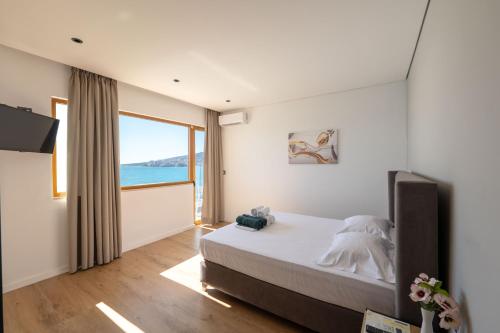 a bedroom with a bed and a large window at Blue Bay Hotel in Sarandë