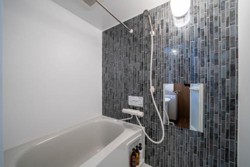 a bathroom with a bath tub and a mirror at LudiCent717 - Vacation STAY 08159v in Toyohira