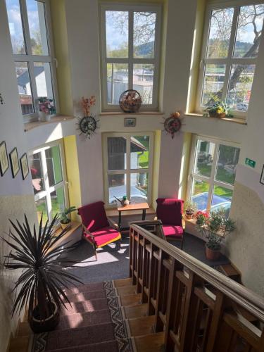 a living room with red chairs and windows at Vila Šebest in Volary