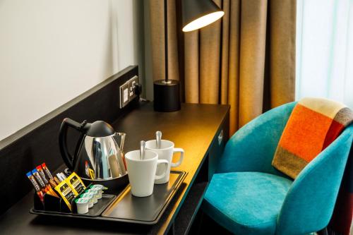 a hotel room with a table and a blue chair at ibis Styles Paignton in Paignton
