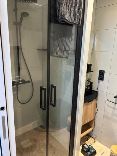 une douche avec une porte vitrée dans une salle de bain dans l'établissement Bienvuenue au 422, à Saint-Raphaël