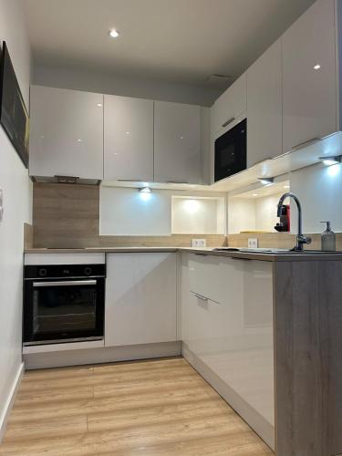 une cuisine avec des armoires blanches et un évier dans l'établissement Bienvuenue au 422, à Saint-Raphaël