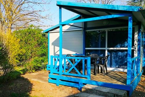 a blue shed with a table and chairs in it at Camping L'oasis Du Berry in Saint-Gaultier