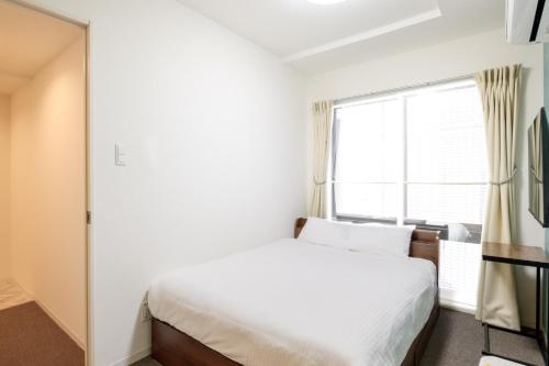 a bedroom with a white bed and a window at LudiCent717 - Vacation STAY 08165v in Toyohira