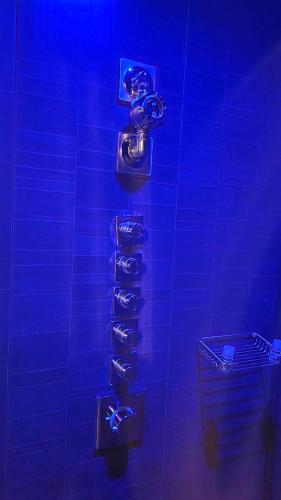 une pièce bleue avec un support de chaussures sur un mur dans l'établissement Suite Chic - Antre-parenthèse, à Gravelines