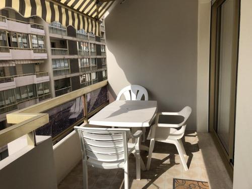 une table et des chaises dans une pièce avec une fenêtre dans l'établissement Cannes proche Croisette - Studio moderne balcon, à Cannes