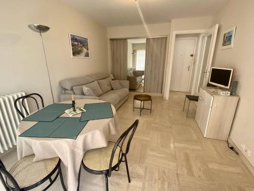 un salon avec une table et un canapé dans l'établissement Cannes proche Croisette - Studio moderne balcon, à Cannes