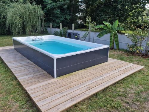 un bain à remous sur une terrasse dans une cour dans l'établissement Maison spa de nage port plage bassin d'Arcachon, à Audenge
