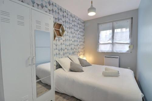 a bedroom with a white bed and a window at Les Apparts du Pont Vert - lit double - WiFi - tout inclus - 5 in Troyes