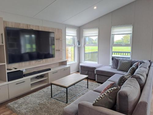a living room with couches and a flat screen tv at North Shore Holiday Park, Skegness in Winthorpe