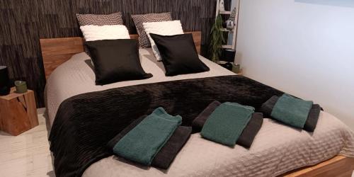 a large bed with black and green pillows on it at Sweet Dreams in Visé