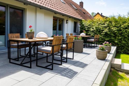 a patio with a wooden table and chairs on it at Haus Amore-Familienidyll am See in Neubrandenburg