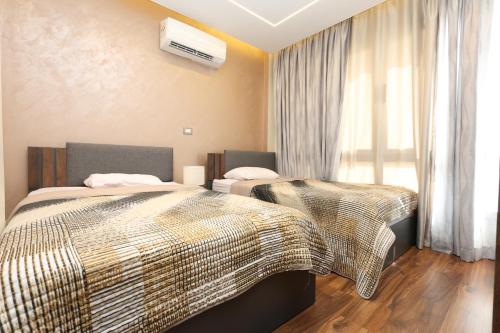 a hotel room with two beds and a window at Madinaty Gateway Prime Apartment B12 in Madinaty