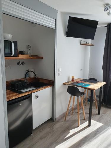 une petite cuisine avec un évier et une table dans l'établissement Appartement 50m2 indépendant dans maison familiale, à Arnage