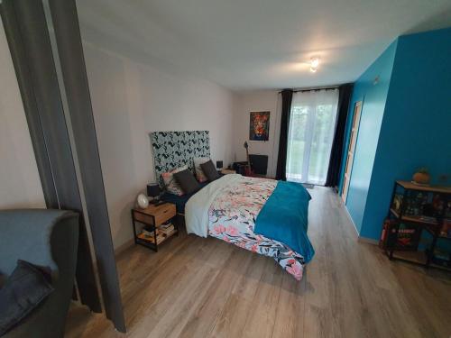 une chambre avec un lit aux murs bleus et au parquet dans l'établissement Appartement 50m2 indépendant dans maison familiale, à Arnage