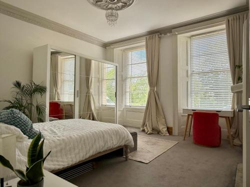a bedroom with a bed and a mirror and windows at Entire Apartment by City Centre & Harbourside in Bristol
