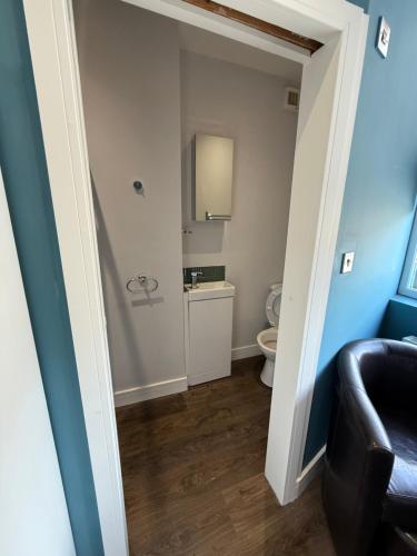 a small bathroom with a toilet and a chair at Turquoise Garden in Macclesfield