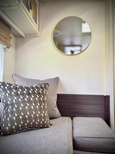 a couch in a room with a mirror on the wall at Riverside Retreat in a Luxe Caravan in Sabie