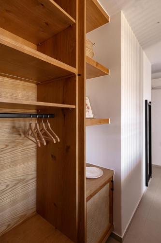 a bathroom with wooden shelves and a sink at Sarana Suites Crete in Kissamos