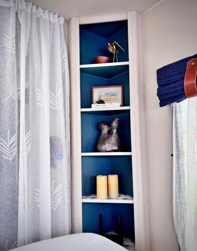 a book shelf with a stuffed animal in a bedroom at Riverside Retreat in a Luxe Caravan in Sabie