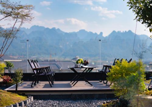a table and chairs on a deck with a view at Zhangjiajie Yujie Hotel in Zhangjiajie