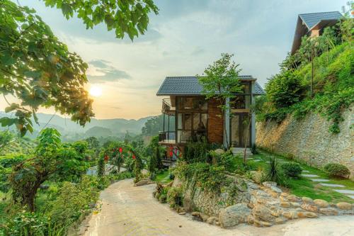 a house on a hill with a dirt road at Sunset Haven Villa - Venuestay in Sóc Sơn
