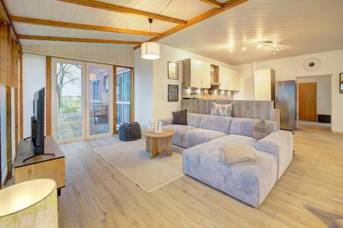 a living room with a couch and a tv at Beejenpütt in Westerdeichstrich