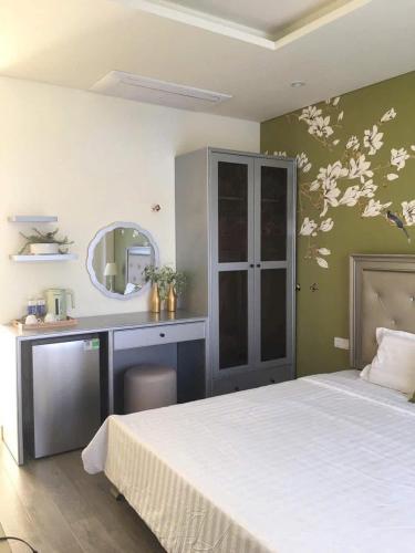 a bedroom with a bed and a desk and a mirror at Wonderland Hồ Tràm - Mocha Viva in Ho Tram
