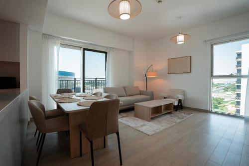 a living room with a table and a couch at Yas Island 3BR plus Maid Pool, Gym, Near SeaWorld & Ferrari World in Abu Dhabi