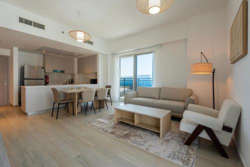 a living room with a couch and a table at Yas Island 3BR plus Maid Pool, Gym, Near SeaWorld & Ferrari World in Abu Dhabi