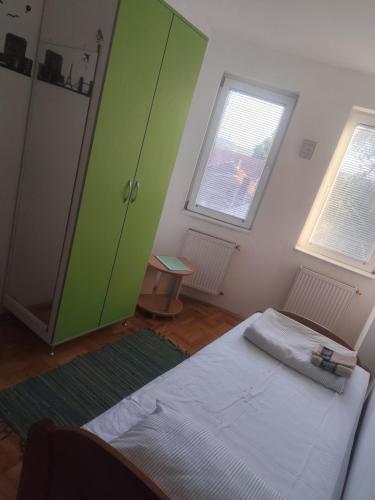a bedroom with a bed and a green cabinet at Agape in Niš