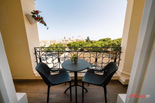 a table and chairs on a balcony with a view at Yolanda Boutique Suites by Zzzing in Birgu