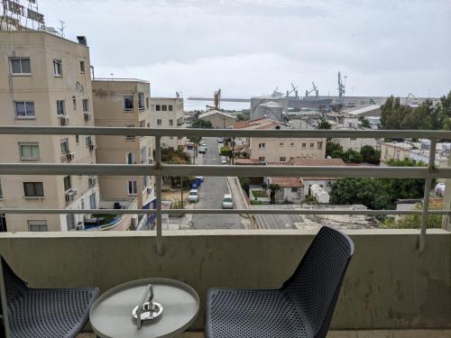 a table and chairs on a balcony with a view of a city at Sunflower Hotel Apartments in Larnaka