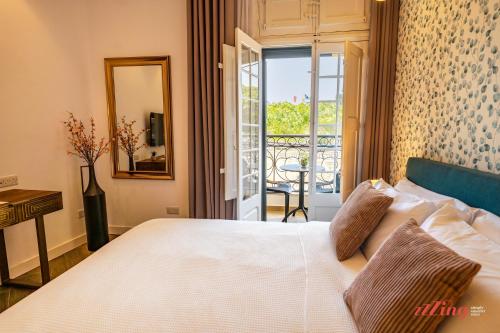 a bedroom with a bed with a view of a balcony at Yolanda Boutique Suites by Zzzing in Birgu